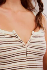 Musculosa acanalada de corte ajustado y corto, con estampado de rayas horizontales en tonos azules y rojos sobre base blanca. Presenta escote cuadrado con abertura frontal y tirantes anchos.