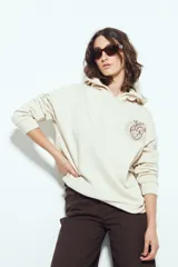 Canguro color beige de silueta relajada con capucha y estampa gráfica de un corazón anatómico en el pecho.