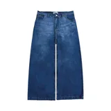 Pantalón de jean azul oscuro con efecto desgastado, corte mega baggy de tiro alto y pierna ancha. Presenta cinco bolsillos y botones personalizados.