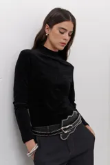 Polera de terciopelo color dorado, con cuello alto y mangas largas.