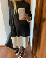 Remerón negro con corte evasé y detalle de bloque blanco en el ruedo.