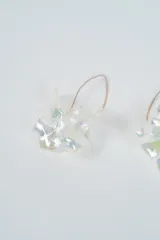 Aros colgantes con diseño de flor en color negro, con gancho metálico dorado.