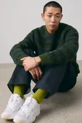 Sweater de punto con diseño de rayas horizontales en tonos verde militar y azul. Tiene cuello redondo y mangas raglán.