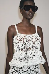 Top de crochet color blanco con diseño de flores tejidas, escote redondo y tirantes finos.