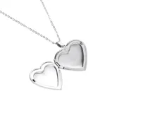 Collar con dije relicario en forma de corazón plateado, con cadena de eslabones finos. El relicario se abre para colocar fotos.