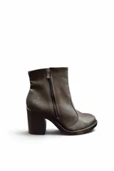 Bota de cuero sintético color marrón, con taco ancho y cierre lateral visible.