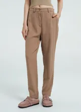 Pantalón de vestir color marrón claro, de corte recto y tiro alto, con pliegues frontales y bolsillos laterales.