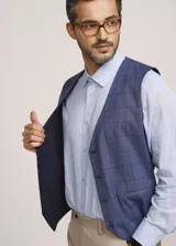 Chaleco reversible Due Volti de corte sastrero, con diseño a cuadros en tonos de gris y cierre frontal con cuatro botones oscuros.