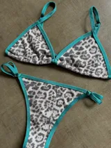 Conjunto de bikini con estampado animal print y ribetes color verde agua.
