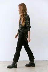 Pantalón marrón de corte recto con cinturón de cuero marrón con hebilla metálica.