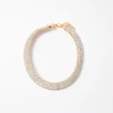 Collar tipo gargantilla rígida de diseño circular, completamente cubierto de cristales brillantes con base metálica dorada y cierre de mosquetón con cadena de alargue.