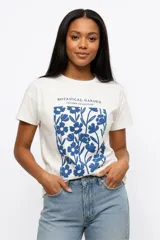 Remera de manga corta color beige, con cuello redondo y diseño de estampado floral grande en el frente.