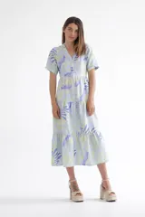Vestido midi celeste con estampado de hojas en tonos lila y verde, corte evasé, cuello camisero, manga corta y falda escalonada.