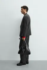 Blazer de corte regular confeccionada en tejido con lana, con diseño de botonadura cruzada. Presenta cuello con solapas de pico, manga larga con puños abotonados, bolsillos de solapa en la cadera y abertura central en la espalda.