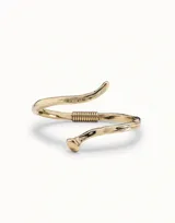 Pulsera abierta de diseño orgánico con acabado en baño de oro de 18k, que presenta un detalle de resorte central y extremos con forma de clavo.