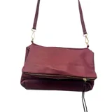 Cartera tipo bandolera de cuero sintético con textura granulada, color bordó. Cuenta con una solapa frontal con cierre metálico y correa larga ajustable.