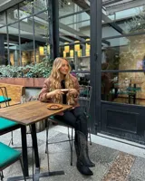 Botas cowboy de cuero negro con bordados decorativos en color ocre.