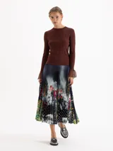 Top de tejido de punto fino color negro, con ajuste al cuerpo, cuello redondo y mangas largas que terminan en puños acampanados con detalle de tejido calado.