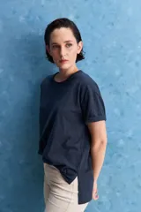 Remera negra de calce amplio, confeccionada en algodón liviano, con cuello redondo, mangas cortas y hombros levemente caídos.