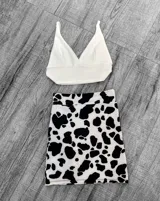 Mini falda blanca con estampado de manchas de vaca en negro.