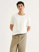 Camiseta de corte regular confeccionada en tela texturizada de color blanco, con cuello redondo y mangas cortas.