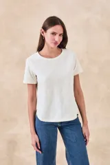 Remera blanca de manga corta con cuello redondo y bordados florales monocromáticos en relieve.