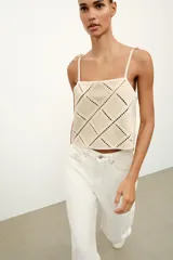 Top de escote recto color beige con tirantes finos ajustables con lazadas. Presenta un diseño con apliques de tejido tipo crochet en patrón geométrico de rombos.