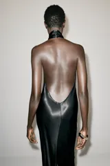 Vestido largo de satén negro, con cuello halter, espalda descubierta y cierre posterior con botones, perteneciente a la colección Zara Woman Collection.