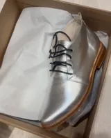 Botas acordonadas marrones de cuero vacuno con suela clara.