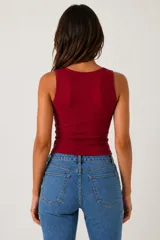 Top sin mangas al cuerpo, de color blanco, confeccionado en tejido acanalado, con diseño cut-out frontal en el escote.
