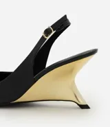 Zapato slingback de punta fina en material sintético efecto charol negro, con tacón anabela de diseño arquitectónico en acabado dorado cromado y tira trasera ajustable con hebilla.