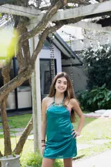 Vestido corto azul con escote halter y espalda descubierta. Presenta detalles de encaje negro en el escote y los laterales.