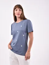 Remera azul con estampado de estrellas blancas, cuello redondo y mangas cortas con frunce en los hombros.