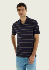 Remera polo de manga corta, color azul marino con diseño de rayas horizontales en tono tostado. Cuenta con cuello clásico y tapeta corta con botones.