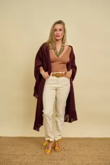 Ruana de lana color bordó con terminación de flecos en los extremos y diseño en picos en la espalda.