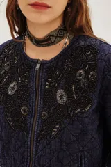 Campera corta acolchada color azul marino con cierre frontal y bordados florales en negro con cuentas y lentejuelas en el pecho y parte superior.