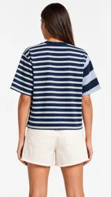 Remera oversize de manga corta con diseño a rayas horizontales en azul marino y blanco, con detalle de patrón de rayas más finas en una de las mangas.