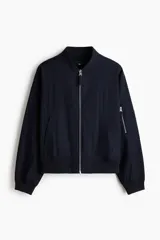 Campera bomber en mezcla de algodón y nylon color azul marino, con cuello elevado acanalado, cierre frontal, bolsillos laterales y un bolsillo con cierre en la manga.