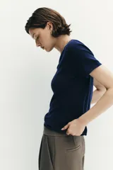 Jersey de punto de cuello redondo y manga corta, con diseño minimalista y textura suave.