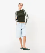 Musculosa básica de cuello alto, sin mangas, confeccionada en una mezcla de algodón, modal y elastano. Presenta un diseño ajustado y minimalista, ideal para uso diario.
