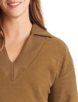 Buzo de punto suave marca Cyrus, color blanco, con cuello solapa y escote en V. Presenta diseño de hombros caídos, mangas 3/4 con puños largos de tejido rib al tono y corte holgado con tajos laterales en el ruedo.