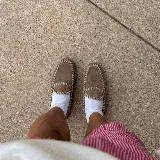 Zapato mocasín de cuero color marrón, confeccionado artesanalmente con costuras de tientos de cuero pasados a mano y punta cuadrada.