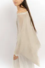 Blusa color beige de hilo con mangas amplias y terminación en picos.