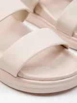 Sandalia baja negra de símil cuero con doble tira ancha sobre la capellada y plataforma de 2 cm.