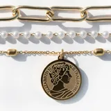 Collar triple dorado: cadena gargantilla de eslabones pequeños, cadenita media con perlas y cadena larga con dije circular de la Reina Isabel.