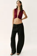 Top de poliamida color bordó con escote en pico, diseño sin mangas y detalle de drapeado frontal con fornitura metálica central.