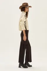 Falda larga de punto en color marrón, confeccionada en una mezcla de viscosa y lurex. Presenta un diseño de corte asimétrico con un volado en el bajo que aporta movimiento y ligereza a la prenda.