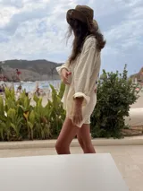 Camisa oversize de lino a rayas blancas y rosadas, con mangas largas y diseño bordado de peces en la espalda.