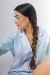 Pijama de algodón a rayas verticales celestes y blancas, compuesto por una camisa de manga larga con botones y un short con elástico en la cintura.