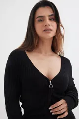 Sweater negro de tejido de punto acanalado, con escote en V y cierre frontal con cremallera circular.